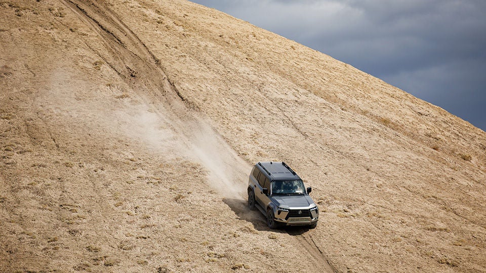 A silver GX on an off-road descent in a desert landscape, Lexus image