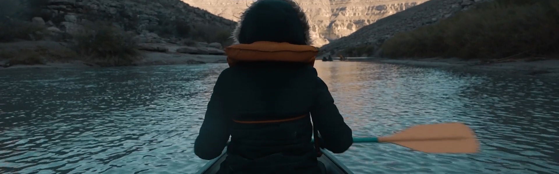 Person paddling a canoe through a rocky canyon with text 'DESTINATIONS BY LEXUS'.