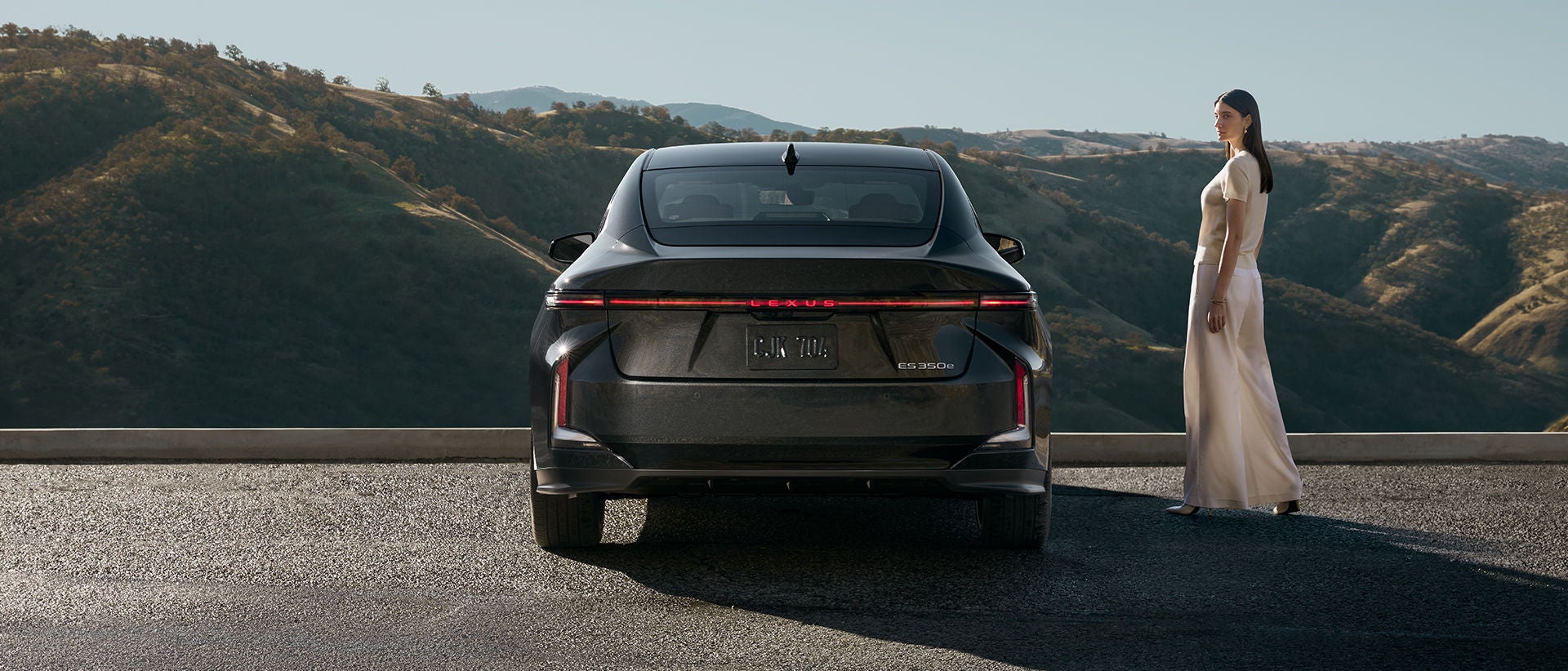Rear angle shot of ES 350e EV in Caviar exterior color.