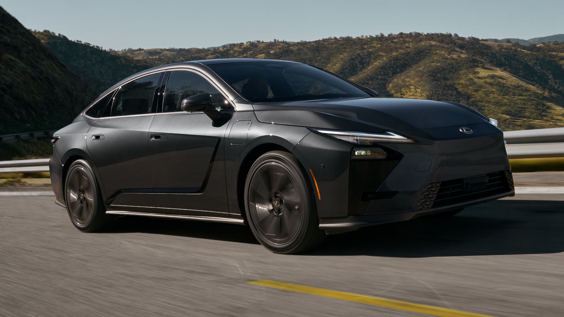ES 350e Luxury in Caviar exterior color with optional 21-inch alloy wheels shown driving on a curving stretch of road.