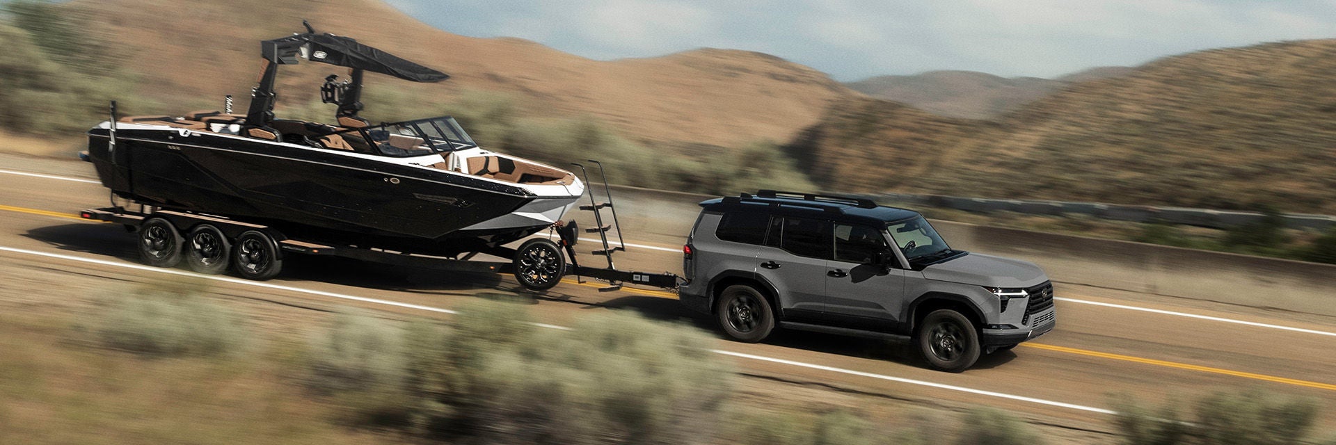 GX 550 Overtrail in Incognito and Black Onyx exterior color combination, shown towing a powerboat.