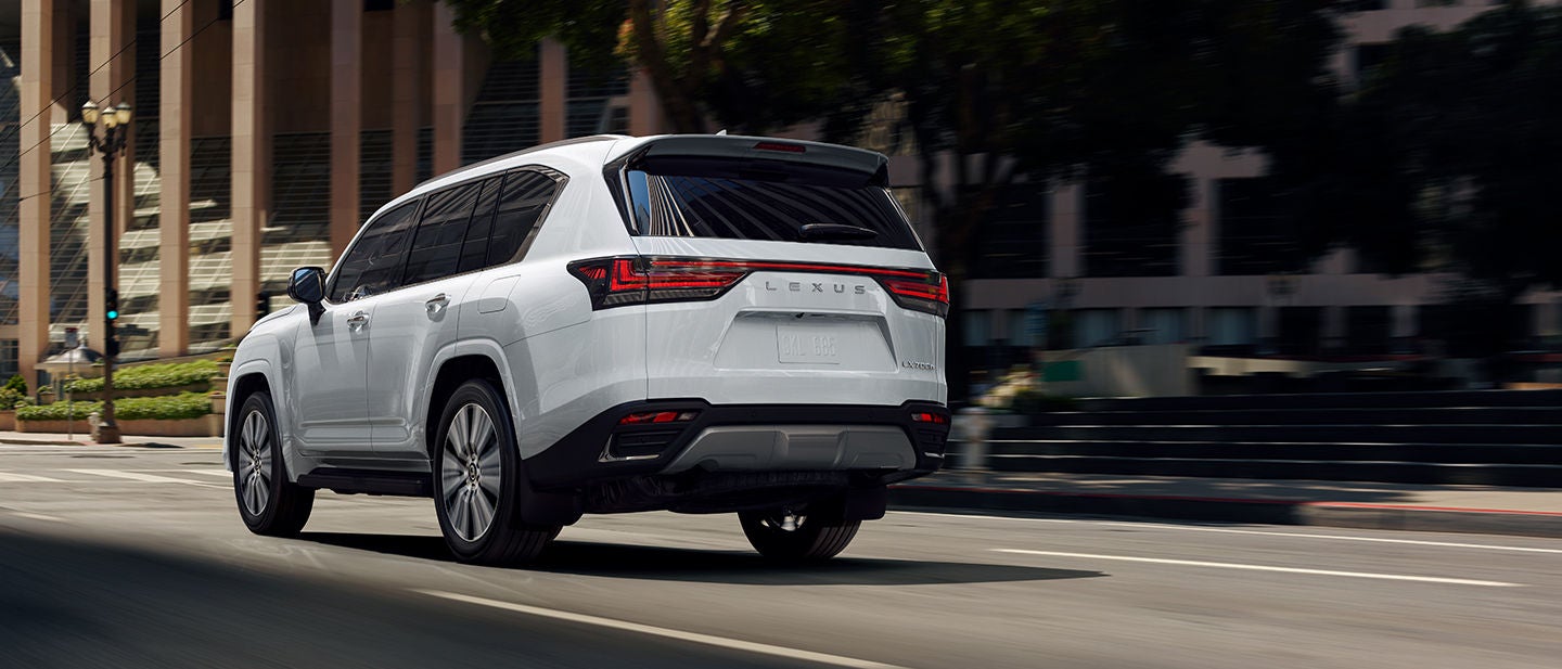 LX 700h F SPORT Handling shown in Ultra White, driving along a winding road.