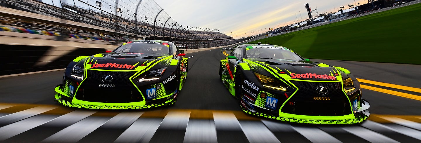 Professional GT3 racers cross the finish line together in their Lexus racecars.