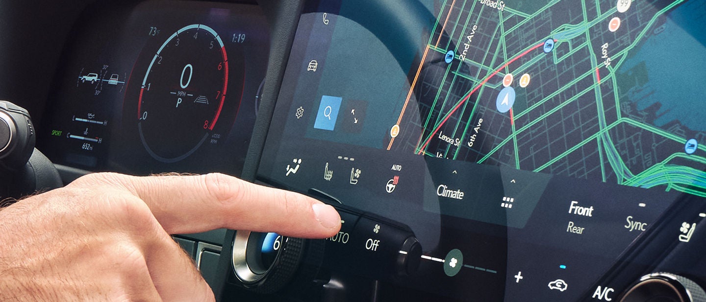 Driver shown interacting with the Lexus Interface touchscreen.